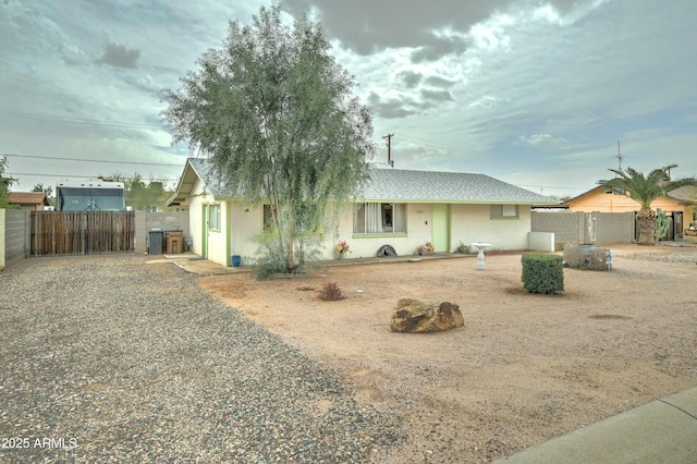 ranch-style house featuring a gate, stucco siding, a shingled roof, and fence