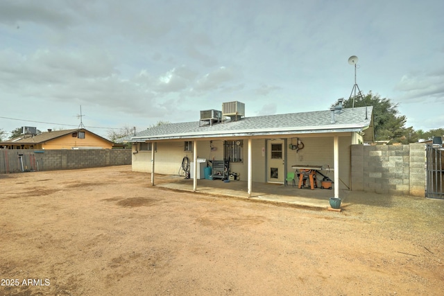 back of house featuring a patio, roof with shingles, and a fenced backyard