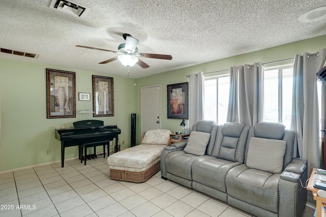 living room featuring light tile patterned floors, a ceiling fan, visible vents, and baseboards