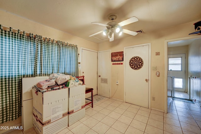 foyer entrance with light tile patterned floors, visible vents, and a ceiling fan