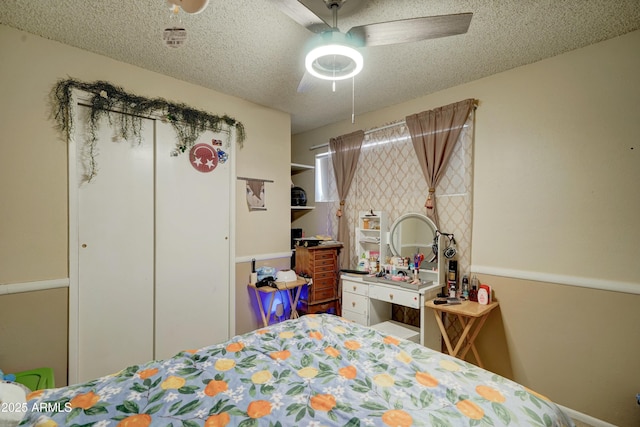 bedroom with a ceiling fan and a textured ceiling