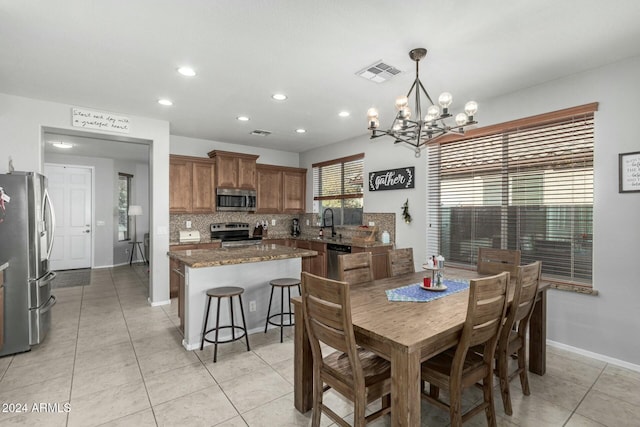 tiled dining area featuring an inviting chandelier and sink