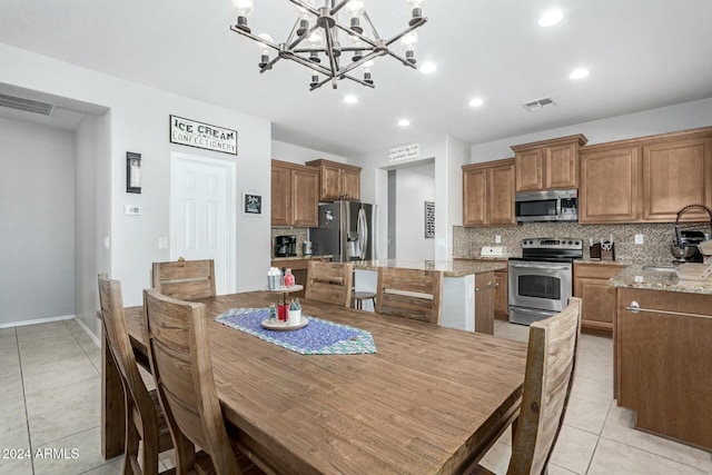 dining room featuring sink, light tile patterned flooring, and a notable chandelier