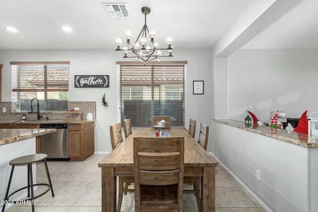 tiled dining room featuring a notable chandelier and sink