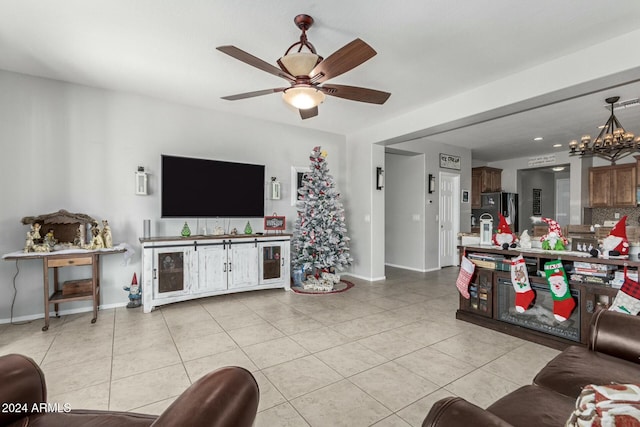 living room featuring ceiling fan with notable chandelier and light tile patterned flooring