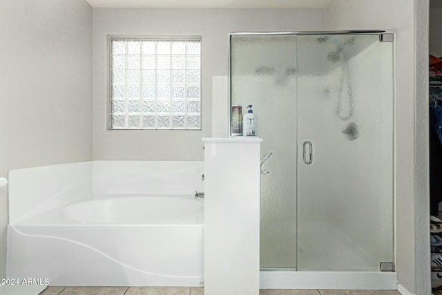 bathroom with tile patterned floors and independent shower and bath