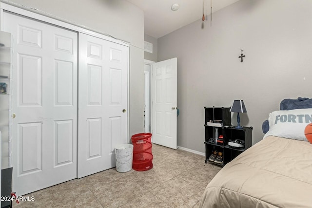 bedroom with light tile patterned floors and a closet