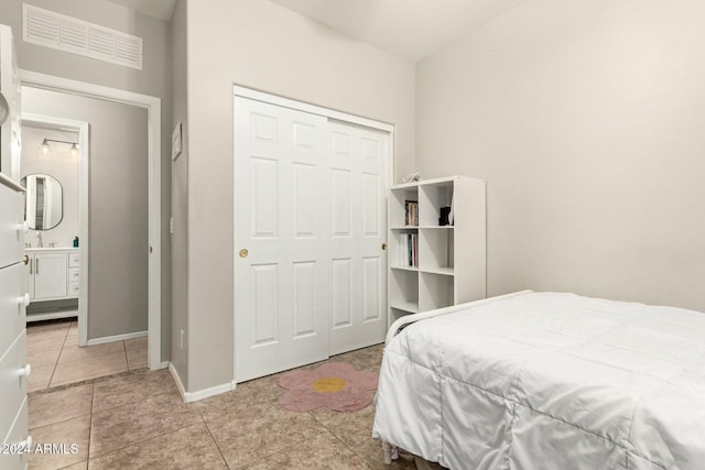 bedroom featuring light tile patterned floors, sink, and a closet