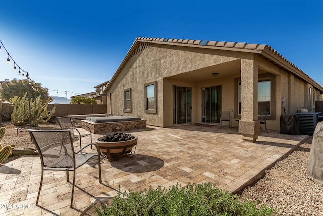 rear view of property featuring a patio and a fire pit