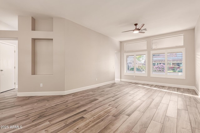 empty room featuring baseboards, ceiling fan, light wood finished floors, and visible vents