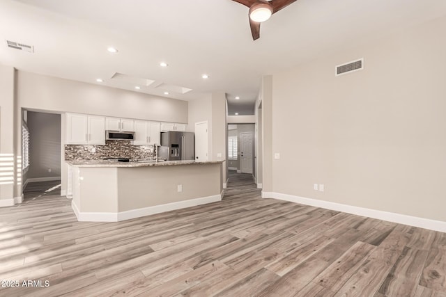 kitchen featuring stainless steel appliances, visible vents, white cabinetry, and light wood-style floors