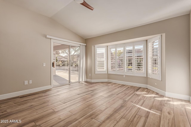 spare room featuring light wood-style floors, baseboards, ceiling fan, and vaulted ceiling