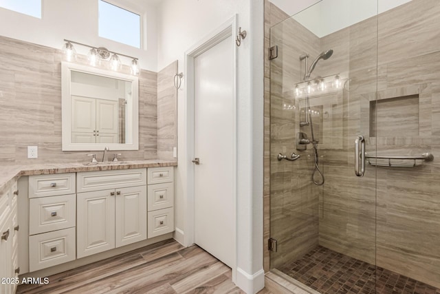full bath featuring vanity, a stall shower, and wood finished floors