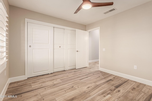 unfurnished bedroom with visible vents, light wood-style flooring, baseboards, and a closet