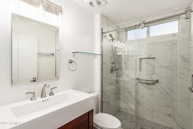 full bath featuring toilet, visible vents, a marble finish shower, and vanity