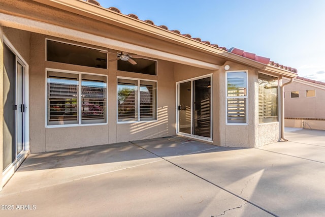 exterior space with stucco siding, a patio area, and ceiling fan