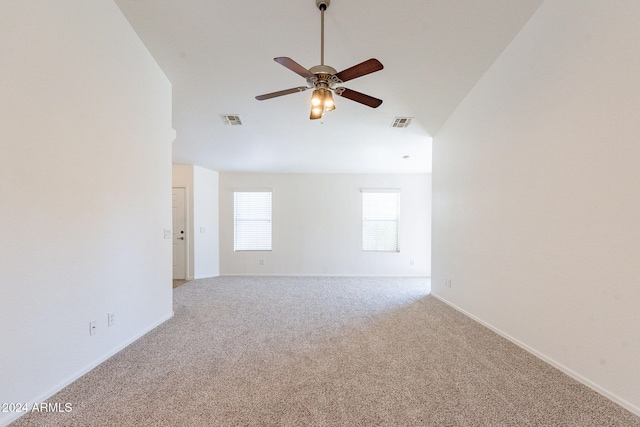 carpeted empty room with vaulted ceiling and ceiling fan