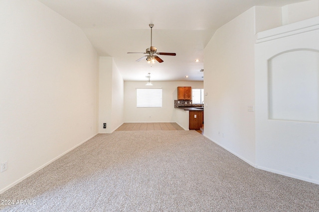 unfurnished living room featuring light carpet, vaulted ceiling, and ceiling fan