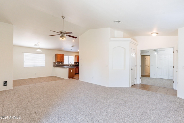 unfurnished living room with lofted ceiling, sink, light colored carpet, and ceiling fan