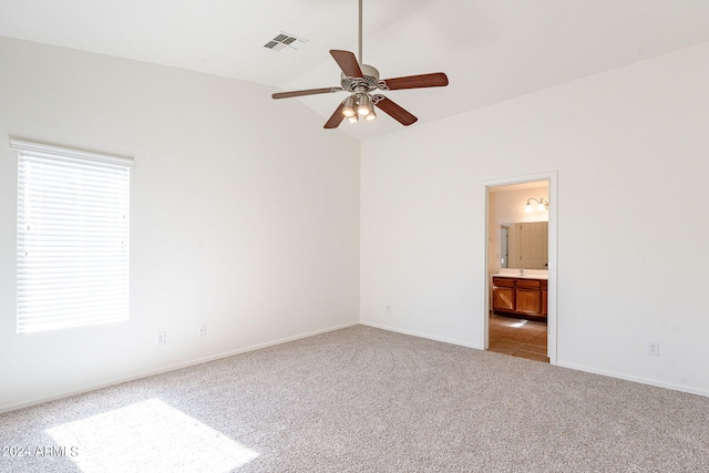 carpeted spare room with vaulted ceiling and ceiling fan