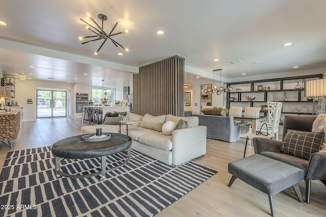 living room featuring visible vents, recessed lighting, light wood-type flooring, and an inviting chandelier