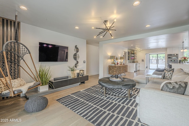 living area with recessed lighting, an inviting chandelier, and wood finished floors