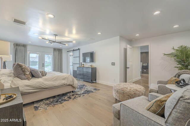 bedroom featuring recessed lighting, visible vents, a barn door, and light wood finished floors