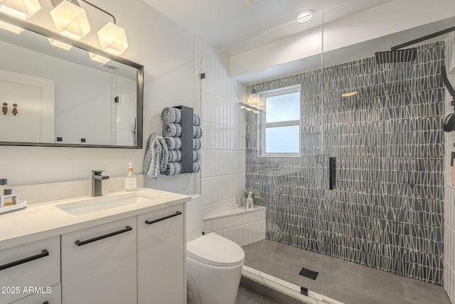 bathroom featuring visible vents, vanity, toilet, and a shower stall
