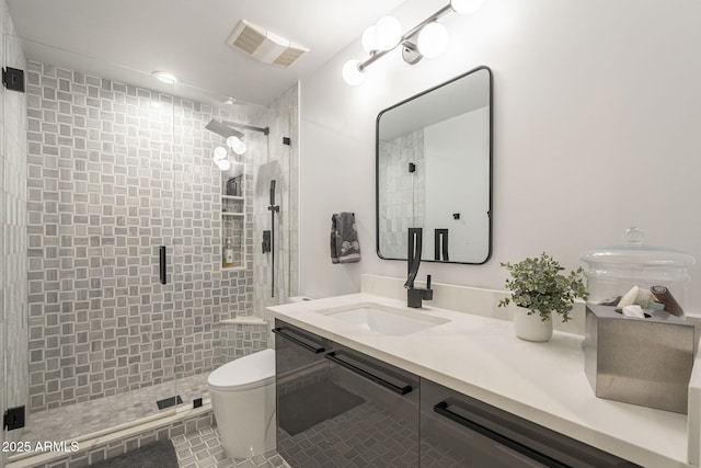 bathroom featuring visible vents, toilet, a stall shower, and vanity