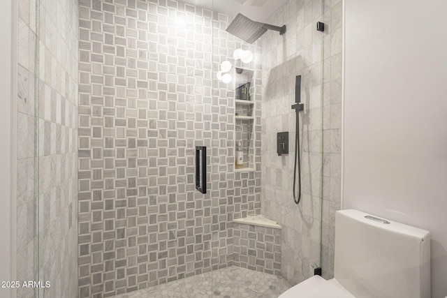 full bath featuring tiled shower and toilet