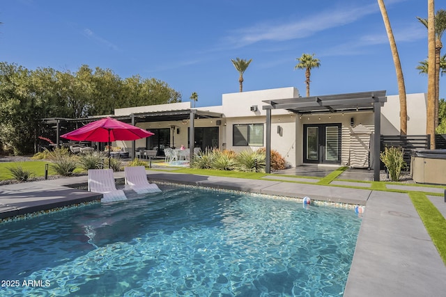 back of property featuring a patio area, an outdoor pool, stucco siding, and french doors