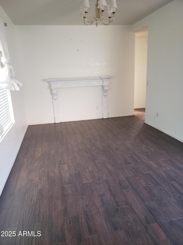 unfurnished living room with a chandelier and dark hardwood / wood-style floors