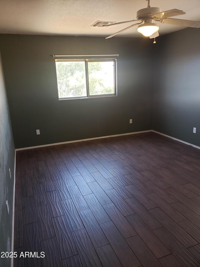 empty room featuring ceiling fan and dark wood-type flooring