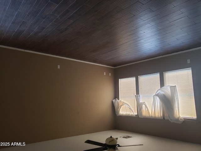 empty room featuring crown molding and wood ceiling