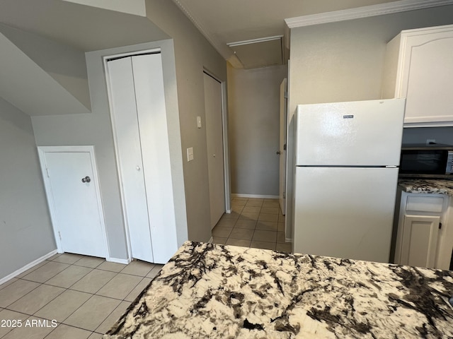 2301 E University Dr Unit 269, Mesa, AZ 85213 - kitchen with freestanding refrigerator, light tile patterned floors, stainless steel microwave, stone countertops, and white cabinets