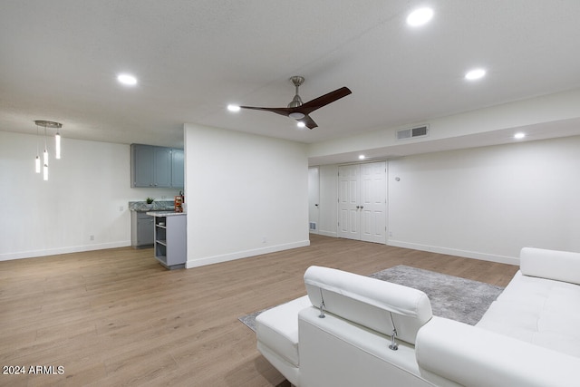 living room with ceiling fan and light hardwood / wood-style floors