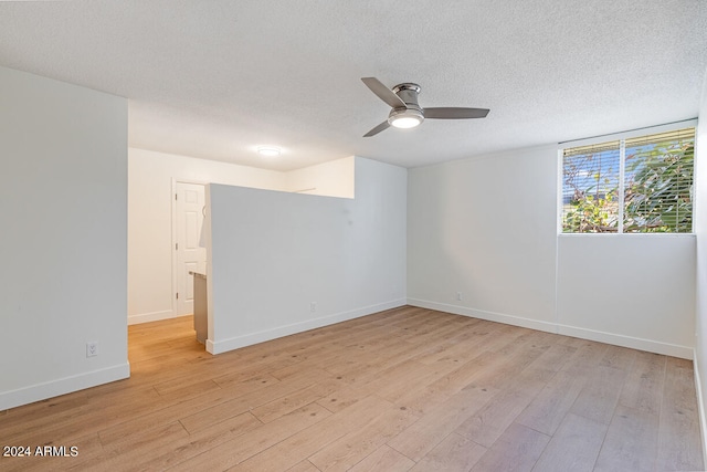 empty room featuring ceiling fan, a textured ceiling, and light hardwood / wood-style floors