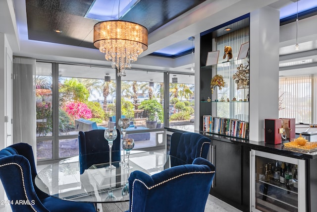 interior space with wine cooler, an inviting chandelier, and a raised ceiling