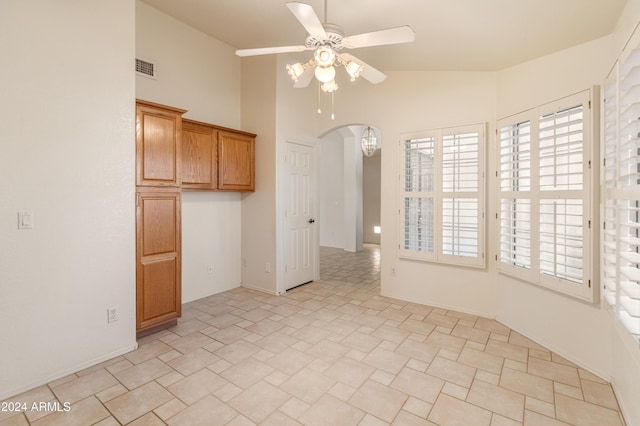 spare room featuring ceiling fan, a wealth of natural light, and vaulted ceiling