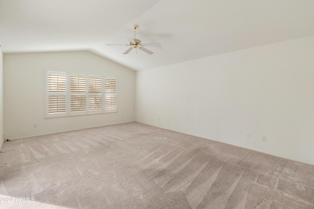 carpeted empty room featuring vaulted ceiling and ceiling fan