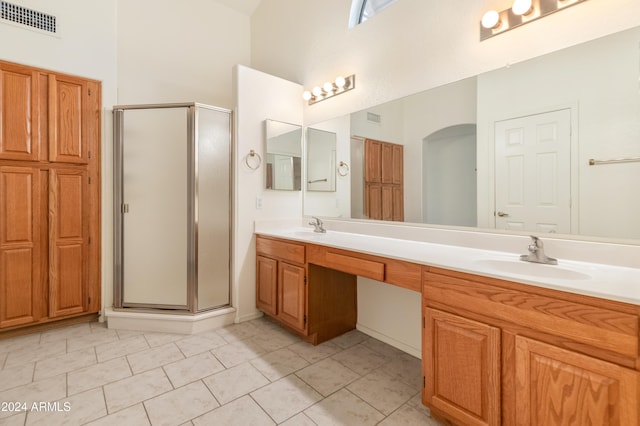 bathroom with tile patterned floors, vanity, and an enclosed shower