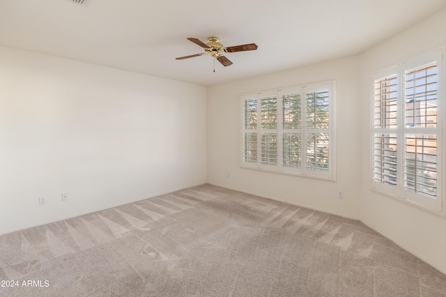 carpeted spare room featuring ceiling fan