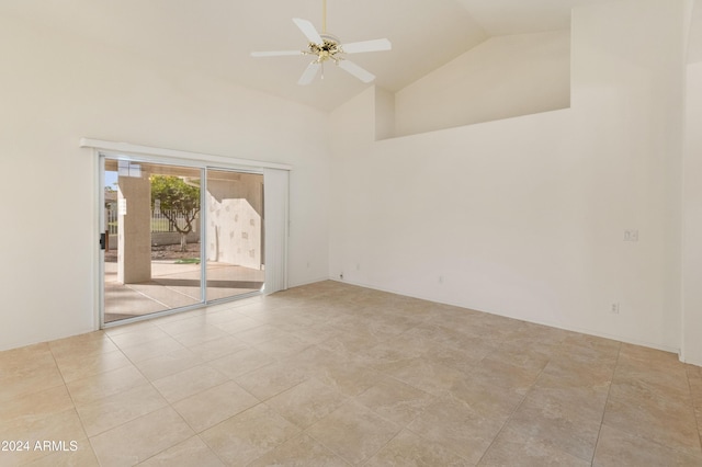 tiled spare room with ceiling fan and high vaulted ceiling