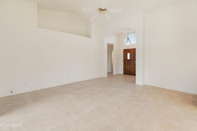 tiled spare room with high vaulted ceiling and ceiling fan