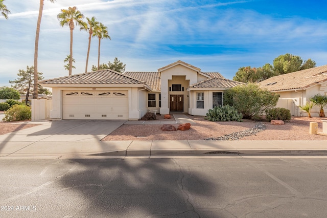 14543 W Bison Path, Surprise, AZ 85374 - view of front of home featuring a tile roof, a garage, stucco siding, and driveway