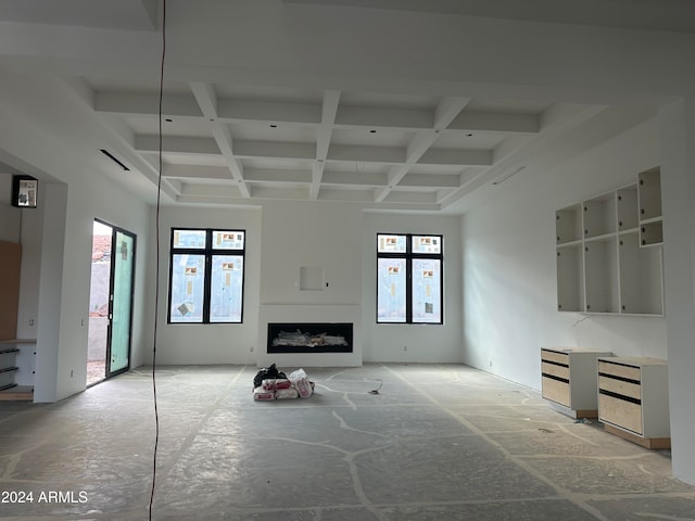 unfurnished living room with a wealth of natural light, coffered ceiling, and a fireplace