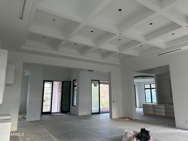 spare room featuring plenty of natural light, coffered ceiling, and a high ceiling