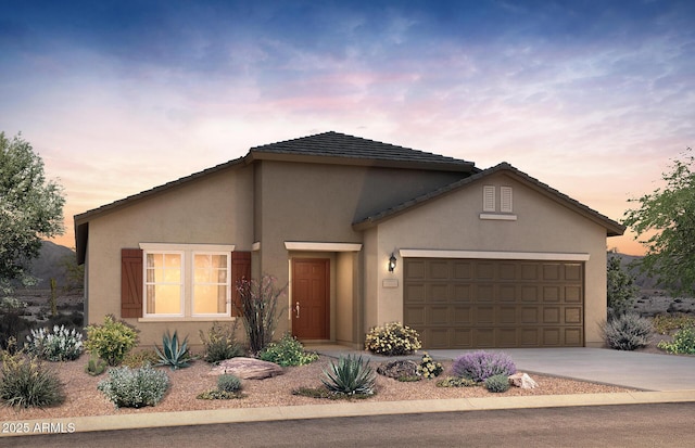 view of front of property with a garage, driveway, and stucco siding