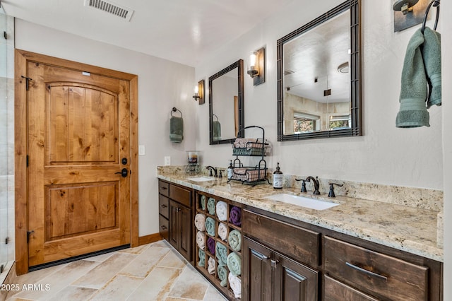 7500 E Old Walnut Canyon Rd, Flagstaff, AZ 86004 - bathroom featuring visible vents, a sink, double vanity, and stone finish flooring