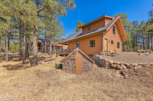 7500 E Old Walnut Canyon Rd, Flagstaff, AZ 86004 - rear view of house featuring a wooden deck, stone siding, and stairway